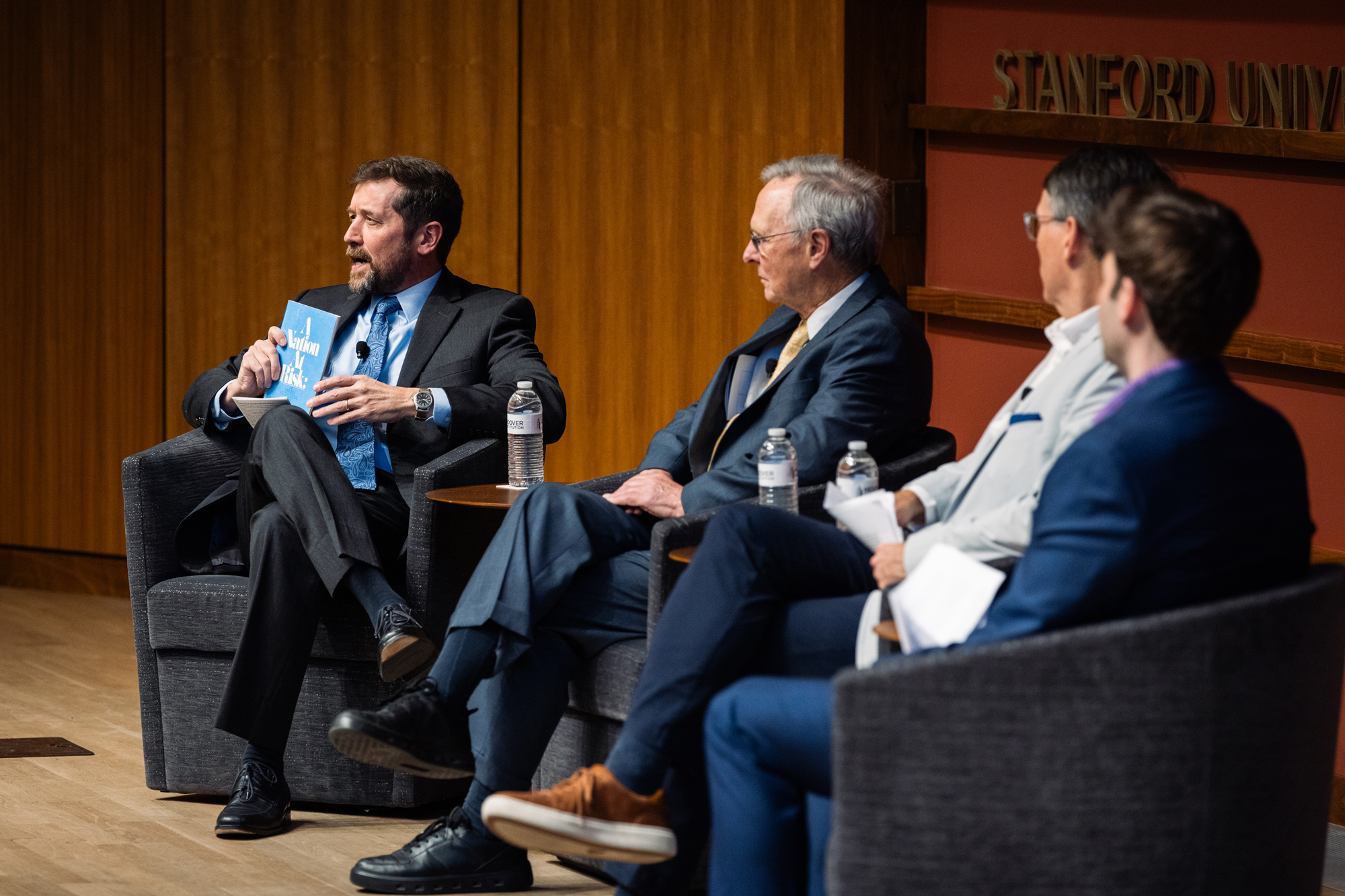 Hoover Education Success Initiative Director Stephen Bowen (left) holds a copy of the original 1983 A Nation at Risk report on US public education during a panel discussing the history of public education reform on January 10, 2025. (Patrick Beaudouin)