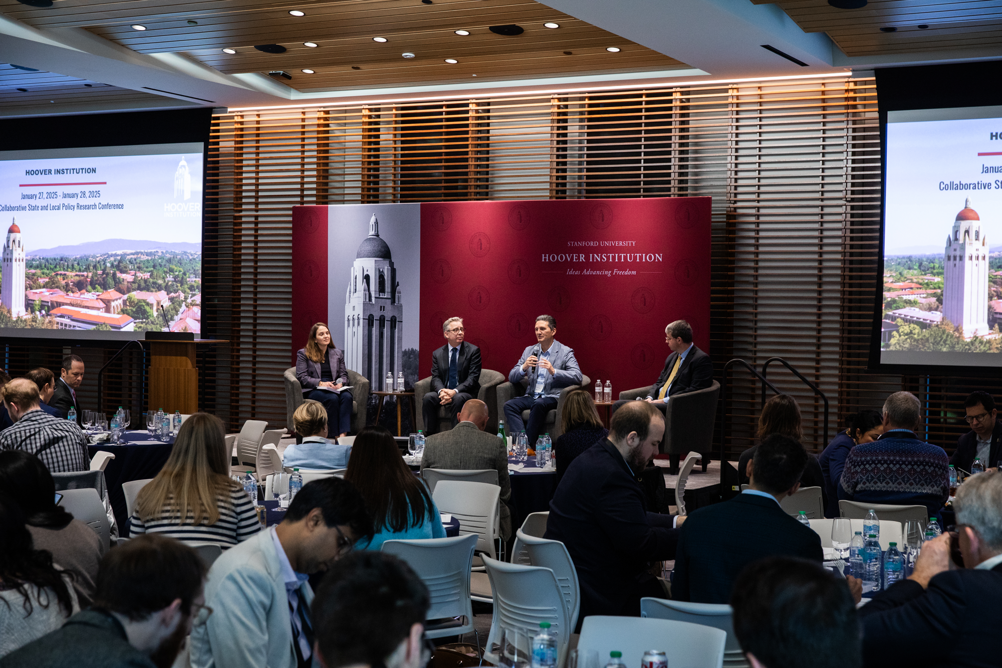 Hoover Fellow Rebecca Lester (left) and officials from California, Hawaii and West Virginia speak about government-academic research partnerships in Shultz Auditorium on January 28, 2025. (Patrick Beaudouin)