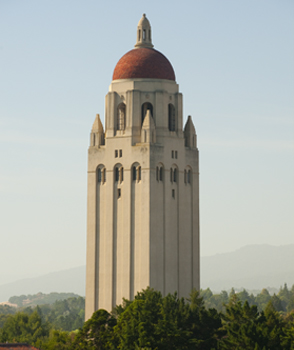 Hoover Tower with blue sky, mountains, and trees