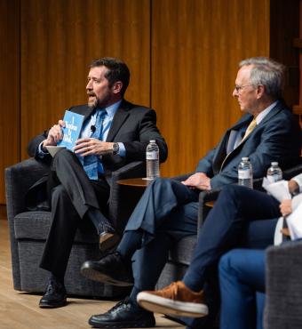Hoover Education Success Initiative Director Stephen Bowen (left) holds a copy of the original 1983 A Nation at Risk report on US public education during a panel discussing the history of public education reform on January 10, 2025. (Patrick Beaudouin)