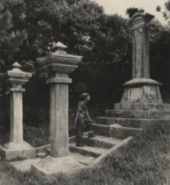 Black and white photograph of a US Navy Seabee exploring a monument on Okinawa durring WWII