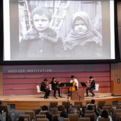 Film on a screen with a string quartet playing below