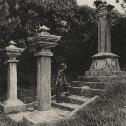 Black and white photograph of a US Navy Seabee exploring a monument on Okinawa durring WWII