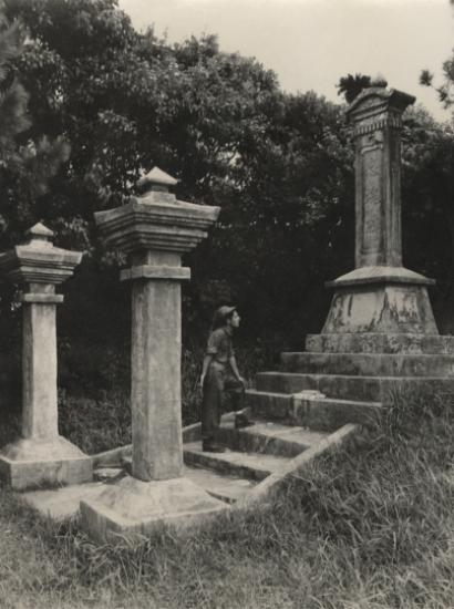 Black and white photograph of a US Navy Seabee exploring a monument on Okinawa durring WWII