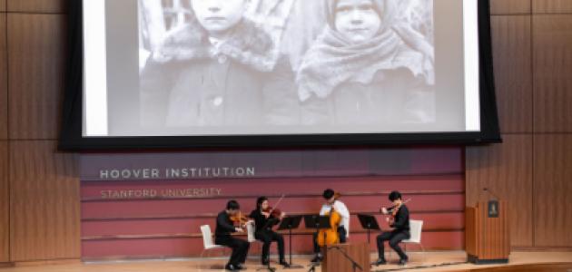 Film on a screen with a string quartet playing below