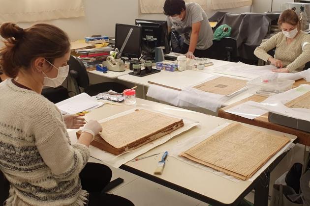 Conservators at Historical Museum of Japanese Immigration working on Burajiru Jiho newspapers