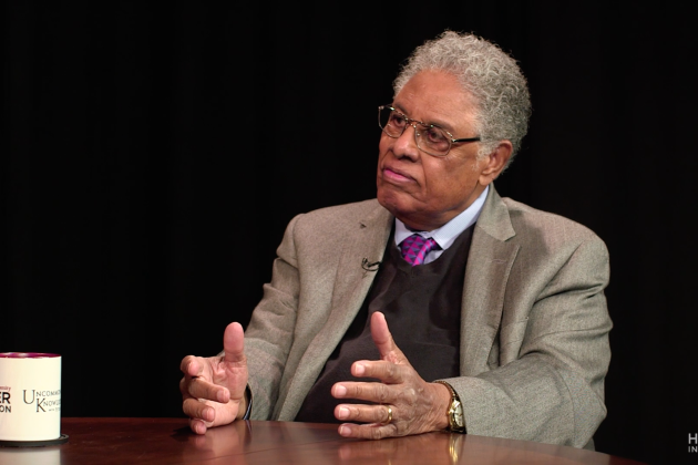 Thomas Sowell in front of a black background with an Uncommon Knowledge mug