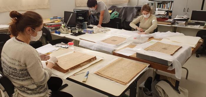 Conservators at Historical Museum of Japanese Immigration working on Burajiru Jiho newspapers