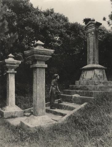 Black and white photograph of a US Navy Seabee exploring a monument on Okinawa durring WWII