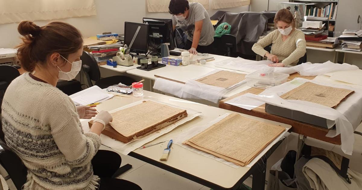 Conservators at Historical Museum of Japanese Immigration working on Burajiru Jiho newspapers