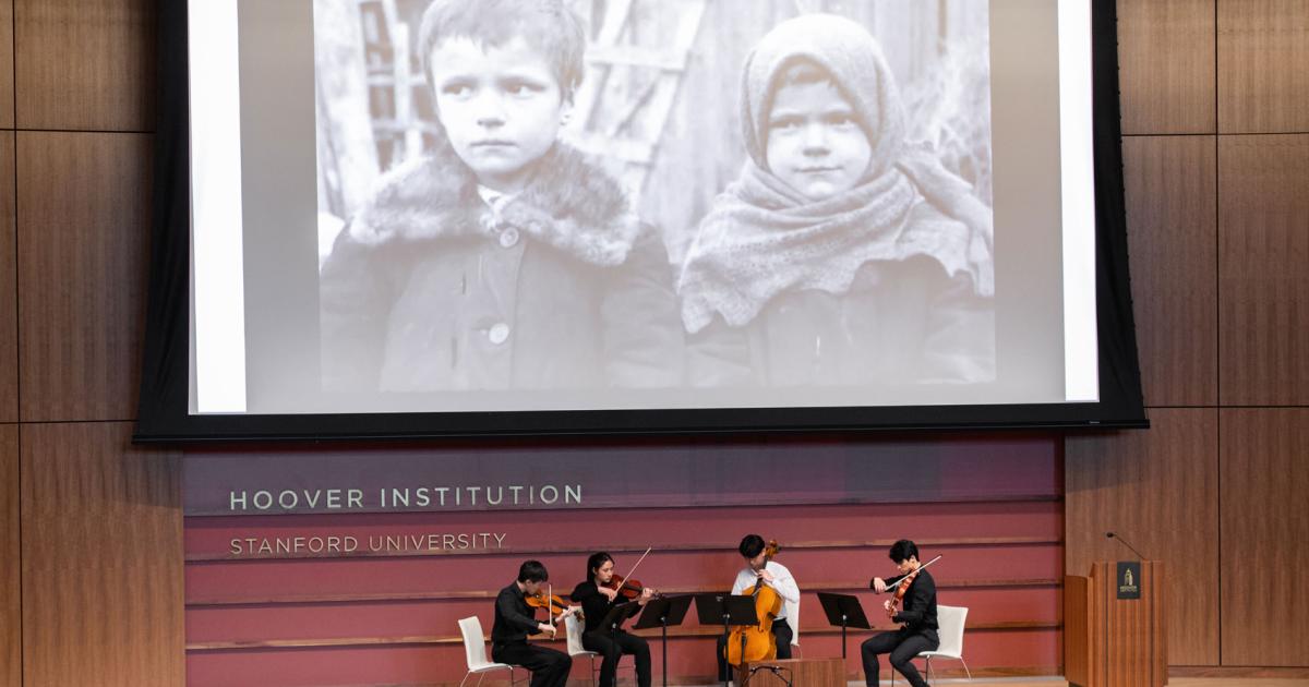 Film on a screen with a string quartet playing below