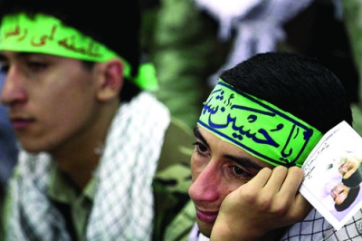 Members of the Basij listen as Ayatollah Ali Khamenei speaks